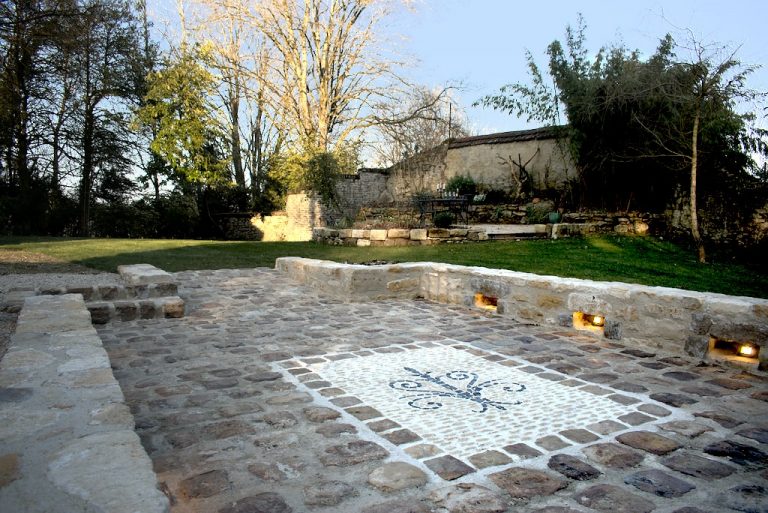 mosaîque en pierres, intégrant une fleur de lys noir en basalte